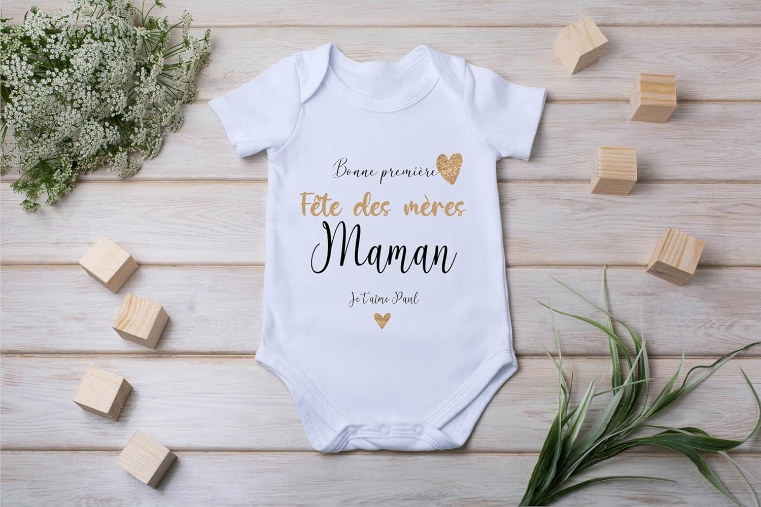 Détail du message imprimé sur un body bébé blanc